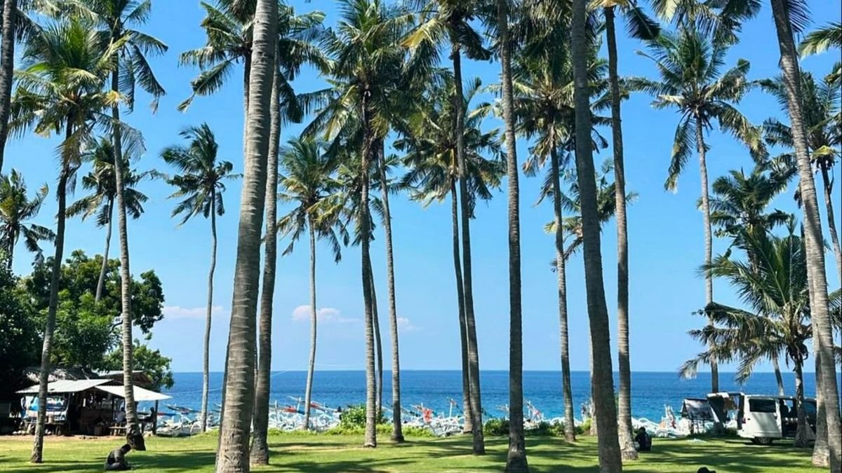 Virgin Beach Bali, featuring white sand, turquoise waves, and serene palm tree-lined coast.